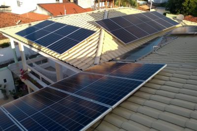 Painéis solares instalados no telhado de uma casa, aproveitando a luz solar para geração de energia limpa e sustentável.